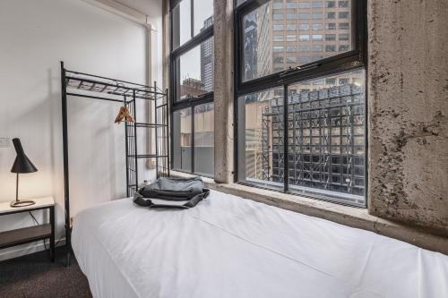 a bedroom with a white bed and a large window at Punthill Apartment Hotel - Manhattan in Melbourne