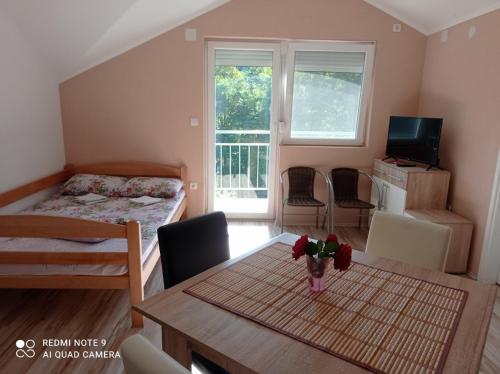a small room with a table and a bedroom at Apartman Alfa 10 in Gornja Toplica