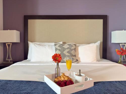 a bed with a tray of fruit and a drink at Private Oasis at Arya in Miami