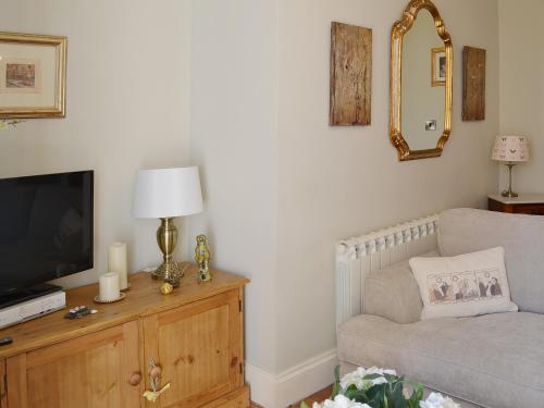 a living room with a couch and a television at Rosie's Retreat in Whitby