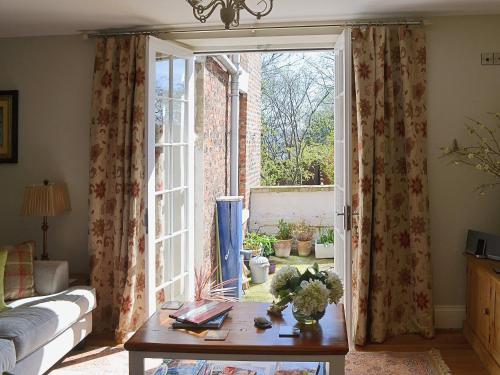 a living room with a table and a large window at Rosie's Retreat in Whitby