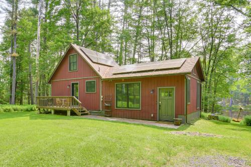 a red house with a porch in a yard at Waterfront Studio with Loft and Dock Near Narrowsburg! in Narrowsburg