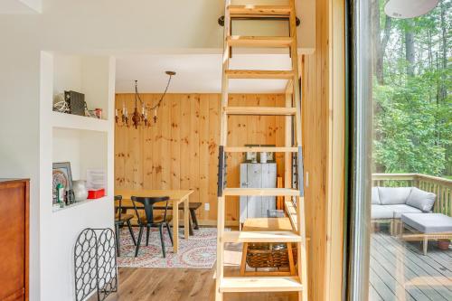 a tiny house with a ladder in a living room at Waterfront Studio with Loft and Dock Near Narrowsburg! in Narrowsburg