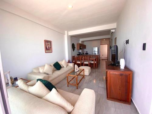 a living room with two couches and a dining room at Frente a la Playa con acceso directo AC Alberca y Elevador in Veracruz