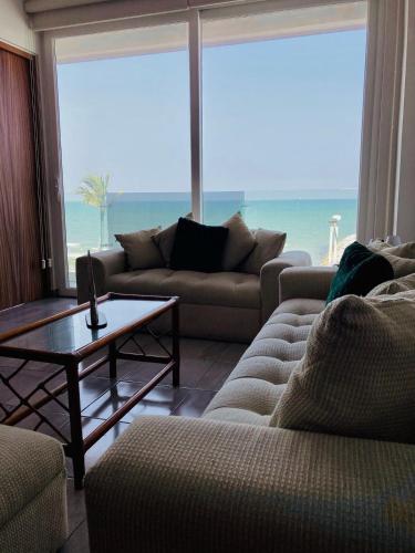 a living room with couches and a view of the ocean at Frente a la Playa con acceso directo AC Alberca y Elevador in Veracruz