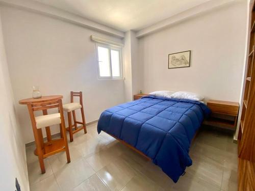 a bedroom with a bed and a table and a chair at Frente a la Playa con acceso directo AC Alberca y Elevador in Veracruz