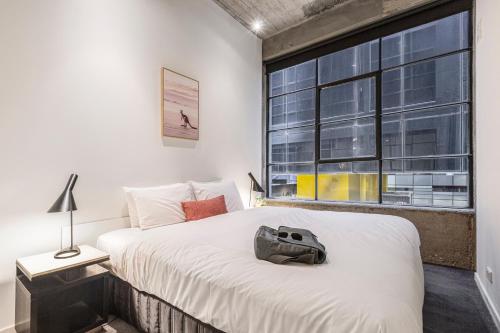 a bedroom with a large bed and a large window at Punthill Apartment Hotel - Manhattan in Melbourne