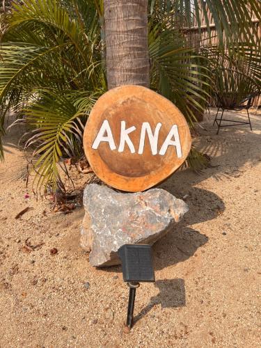 a sign that says akma sitting on top of a rock at Casa Copal Troncones - Bungalows con Alberca Privada in Troncones
