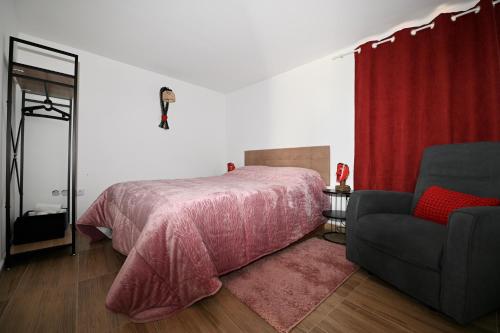 a bedroom with a pink bed and a chair at Casas do Azibeiro in Veigas