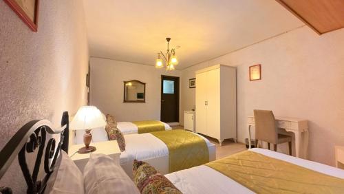 a hotel room with three beds and a lamp at Casa Villa By Kirte in Eceabat