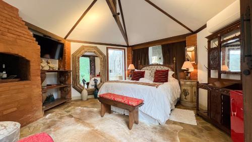 a bedroom with a bed with a red bench in it at Segredo da Serra Guest House in Tiradentes