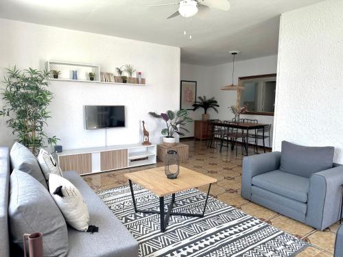 a living room with a couch and a tv at Chalets con piscinas privadas junto al mar in Cala'n Bosch