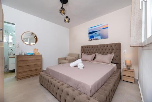 a bedroom with a large bed with a brown couch at Alexandros mini suites in Santorini