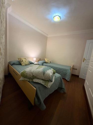 a bedroom with two beds and a light on the ceiling at Piso Moderno Puerto de la Cruz Villa Isabel in Puerto de la Cruz