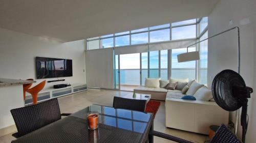 ヌエバ・ゴルゴナにあるLoft Style Beachfront Apartmentのソファとテレビのあるリビングルーム