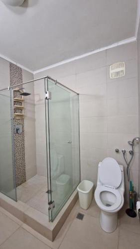 a bathroom with a glass shower and a toilet at Loft Style Beachfront Apartment in Nueva Gorgona