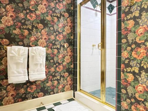 a bathroom with floral wallpaper and a shower with a mirror at Zen House in Princeton