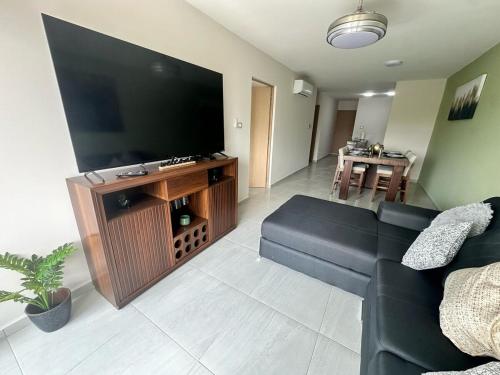 a living room with a couch and a large flat screen tv at Modern Oceanfront Retreat 2BD 2BDR Wifi Pool in Veracruz