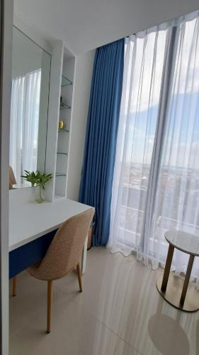 a room with a desk and a large window at Blue Belle Staycation Pollux Habibie in Batam Center