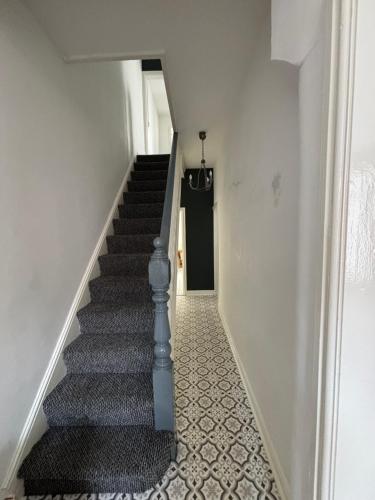 a stairway with a blue rail and a black door at Single room in anfield in Liverpool