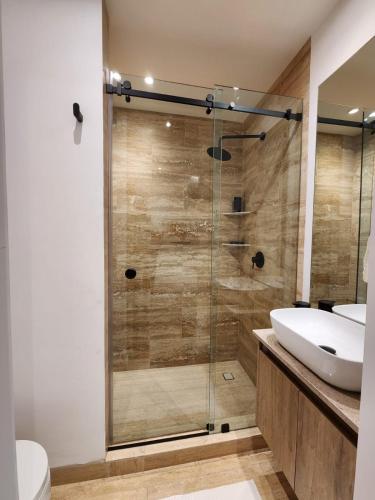 a bathroom with a glass shower and a sink at Steps to Historic C and Reforma in Mexico City