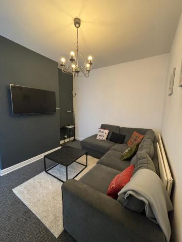 a living room with a couch and a flat screen tv at Cozy Double Room with 5 Minute Walk to Anfield Stadium ideal for Matchdays in Liverpool