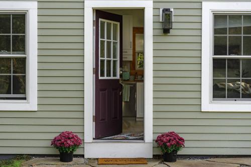 a house with a purple door and two flowers at Red Barn Cabin Near Okemo in Brownsville