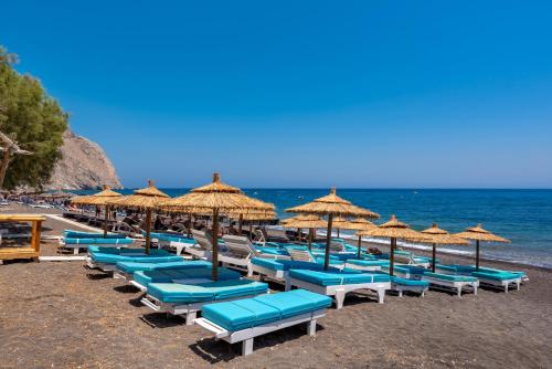a bunch of chairs and umbrellas on a beach at Alexandros mini suites in Santorini
