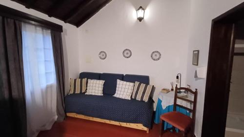 a living room with a blue couch and a table at Quinta do Monte Santo in Vila do Porto