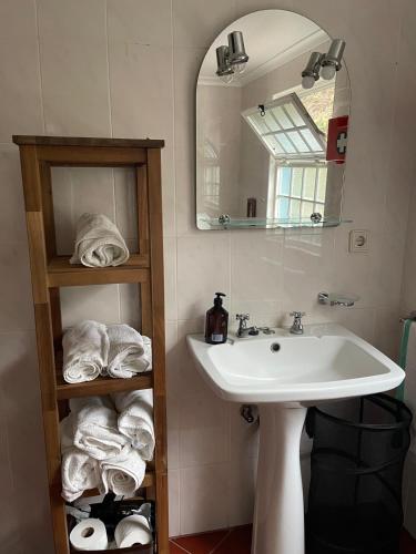 a bathroom with a sink and a mirror and towels at Quinta do Monte Santo in Vila do Porto