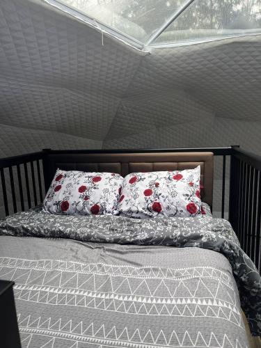a bed with red and white pillows on it at Bubbles in Saint Andrews