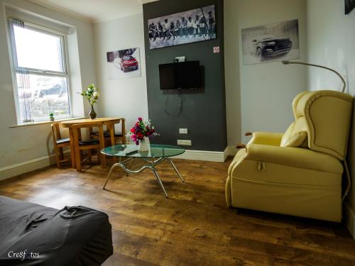 a living room with a couch and a table at Bucknall Lodge Hanley Family Room 1 in Stoke on Trent