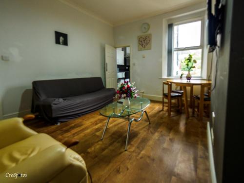 a living room with a couch and a table at Bucknall Lodge Hanley Family Room 1 in Stoke on Trent