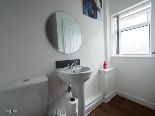 a white bathroom with a sink and a mirror at Bucknall Lodge Hanley Family Room 1 in Stoke on Trent