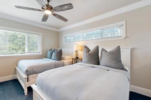 Un dormitorio con dos camas y un ventilador de techo. en Monterey A, en San Clemente