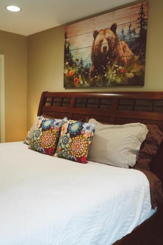a bed with pillows and a painting of a bear at Lakeshore Lodging Apartment G in Homer