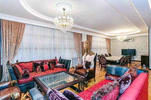 ein Wohnzimmer mit roten Möbeln und einem Kronleuchter in der Unterkunft F1 Track SEA VİEW HOTELAPARTMENT BARBARIS in Baku