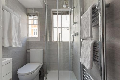 ロンドンにあるSteps Away From Soho, Covent Gardenのトイレとガラスのシャワー付きのバスルーム