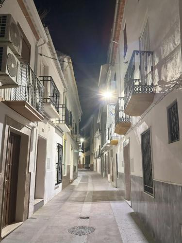 an alley with white buildings and a street light at Casa del Delfin in Iznájar