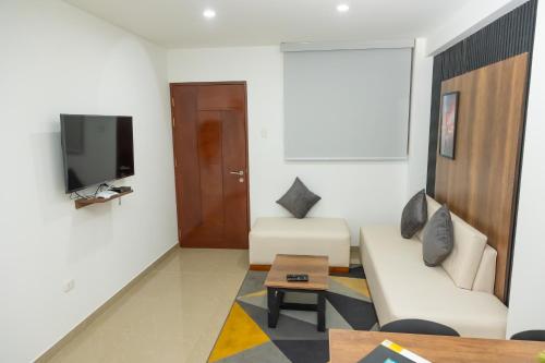 a living room with a couch and a tv at Moderno Departamento en Barranca in Barranca