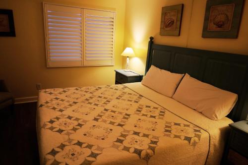 a bedroom with a bed with a quilt on it at Mariner East in Panama City Beach