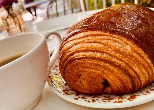 a loaf of bread on a plate next to a cup of coffee at Venice Palace Luxury Suites in Venice