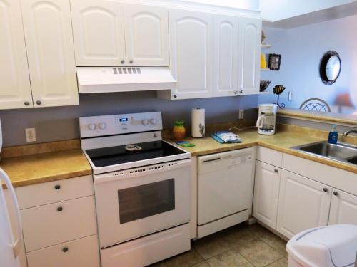 a kitchen with white cabinets and a stove top oven at Mariner East in Panama City Beach