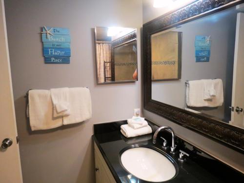 a bathroom with a sink and a mirror and towels at Mariner East in Panama City Beach