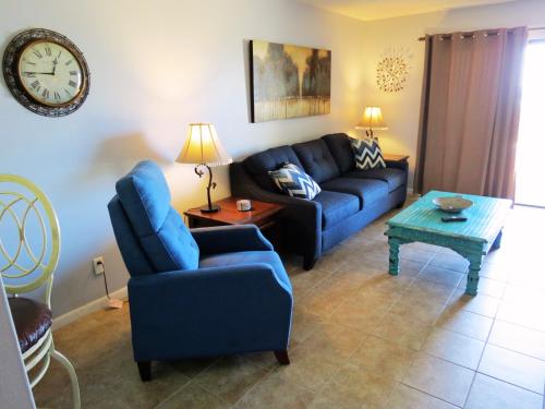 a living room with a blue couch and a table at Mariner East in Panama City Beach