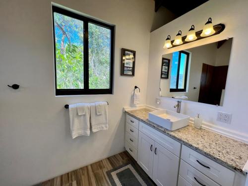 ein Badezimmer mit Waschbecken und Spiegel in der Unterkunft Casa Carolina - Modern Villa with Private Pool in Coral Bay