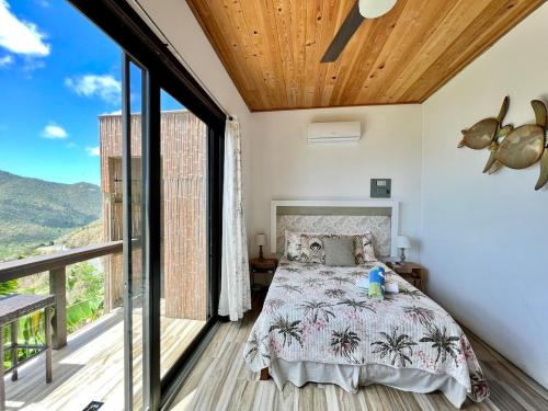 ein Schlafzimmer mit einem Bett und einem großen Fenster in der Unterkunft Casa Carolina - Modern Villa with Private Pool in Coral Bay