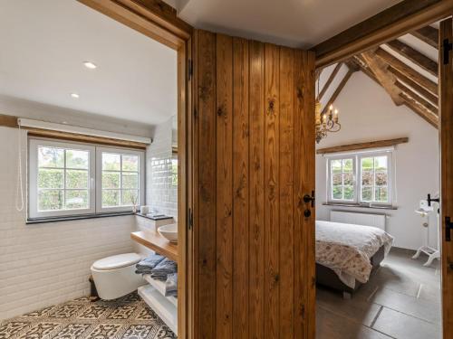 Un baño con inodoro y una cama en una habitación. en Niels, en Nieuport-Bains