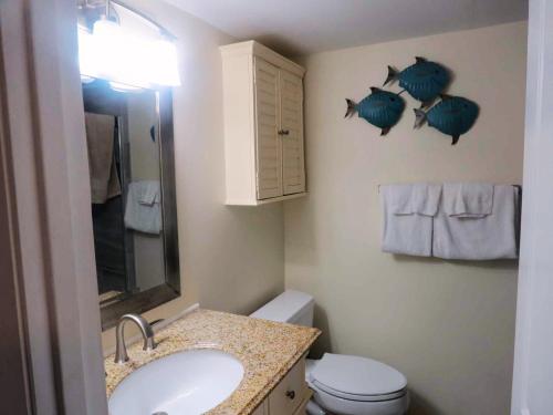 a bathroom with a sink and two fish on the wall at Mariner East in Panama City Beach