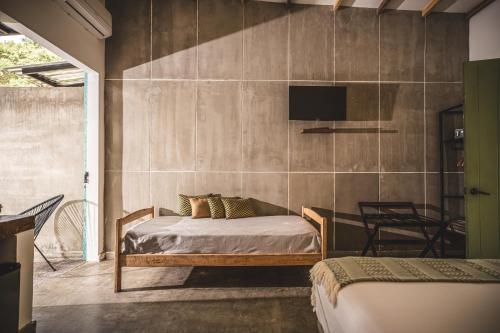a bedroom with a bed and a tv on a wall at Waka Hotel Rural in Honda